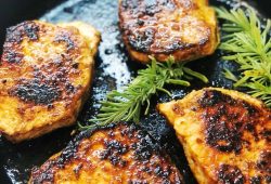 Pan-seared pork chops with rosemary in a cast iron skillet