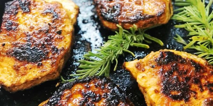 Pan-seared pork chops with rosemary in a cast iron skillet