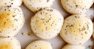 Baked garlic herb cheese bombs on a baking sheet