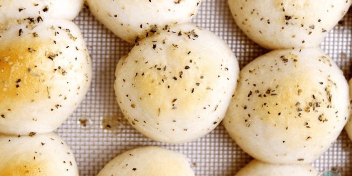 Baked garlic herb cheese bombs on a baking sheet