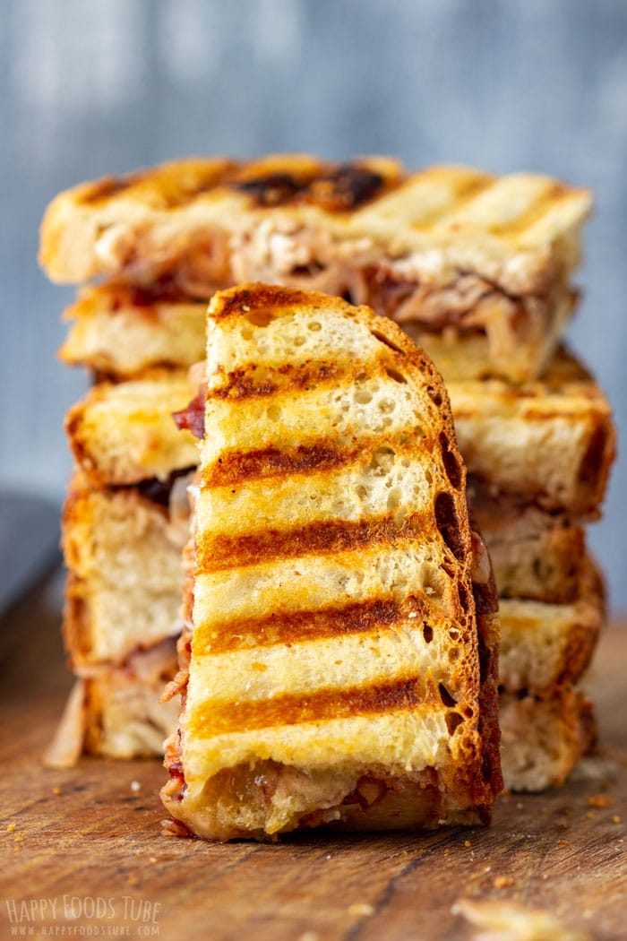 Half of a turkey cranberry panini standing upright showing grill marks and cheddar filling