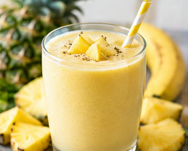 Pale creamy yellow fruit smoothie with a striped straw