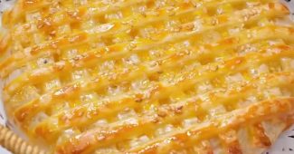 Golden air fryer pineapple pie with a lattice top and sesame seeds in a wicker basket