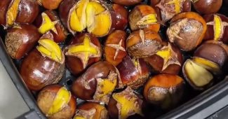 Roasted chestnuts with split shells in an air fryer basket
