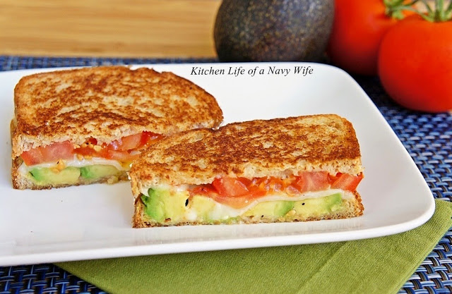 Avocado, mozzarella and tomato grilled cheese sandwich cut in half