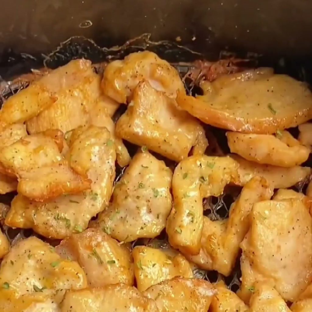 Golden air fryer chicken breast bites sprinkled with chopped celery leaves