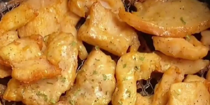 Golden air fryer chicken breast bites sprinkled with chopped celery leaves