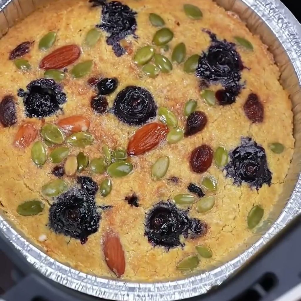 Baked oatmeal cake with blueberries, almonds, pumpkin seeds and raisins in a foil tray