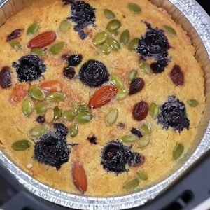 Baked oatmeal cake with blueberries, almonds, pumpkin seeds and raisins in a foil tray