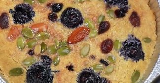 Baked oatmeal cake with blueberries, almonds, pumpkin seeds and raisins in a foil tray