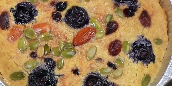 Baked oatmeal cake with blueberries, almonds, pumpkin seeds and raisins in a foil tray