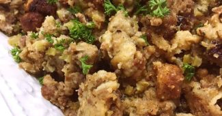 Sausage and herb stuffing with sage sausage and parsley on a white platter
